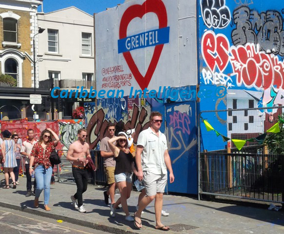 People walk past Love Grenfell sign